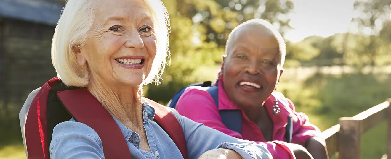 A smiling older couple with backpacks on a hike — photo from the current Insight Eye Center homepage
