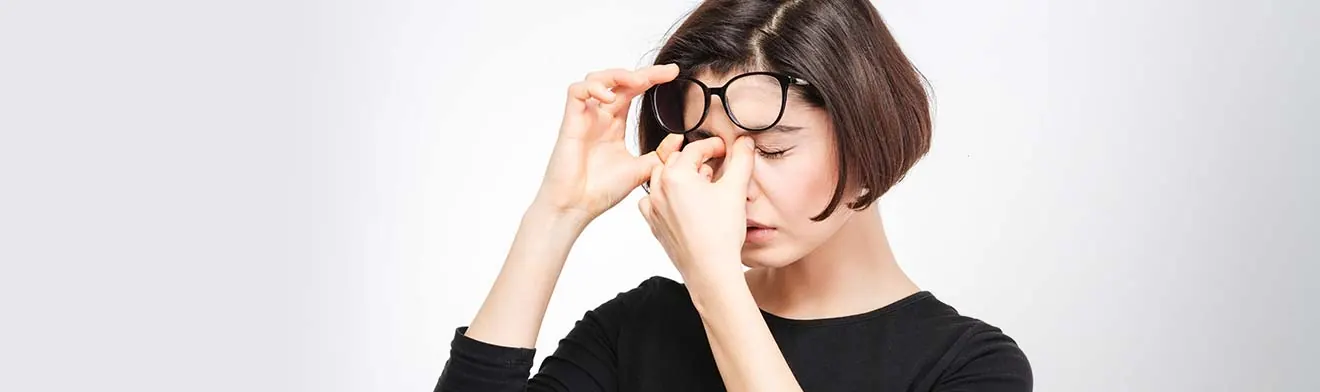 A woman rubbing her eyes under her glasses — banner photo from the current dry eye page