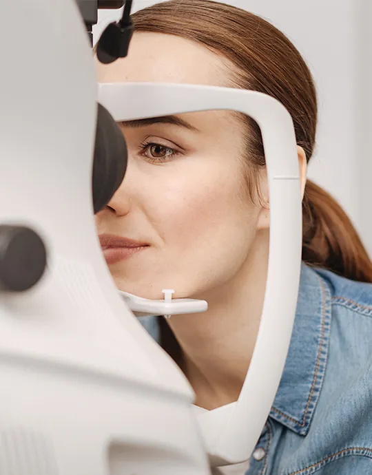 A patient having her vision checked with a phoropter during an eye exam