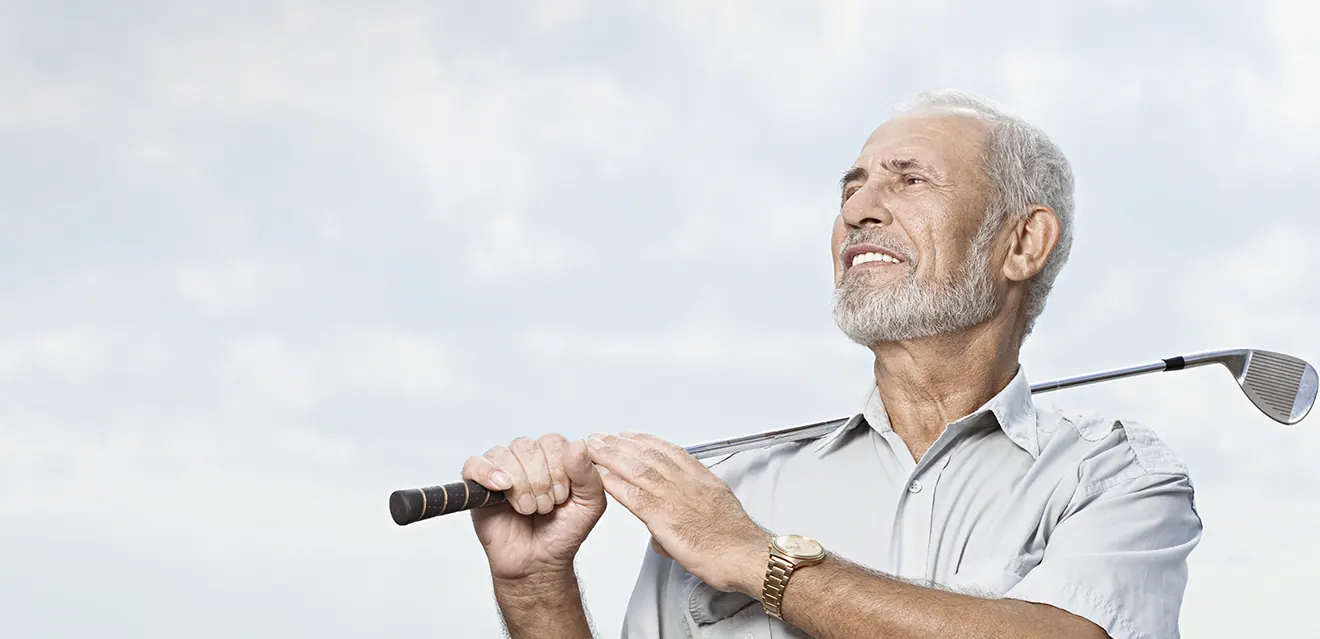 An older man holding a golf club and looking up at the sky — photo from the current Insight Eye Center homepage